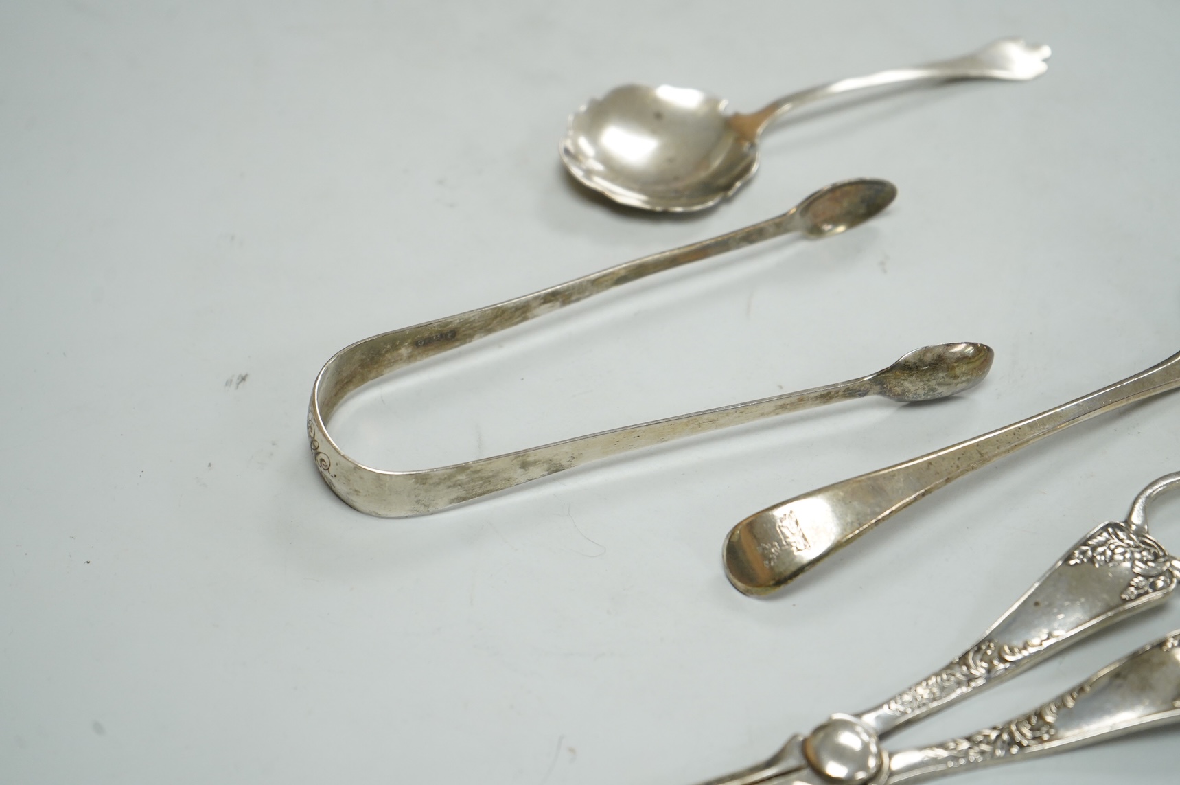 A pair of George V silver grape shears, Josiah Williams & Co, London, 1912, 16.2cm, together with a George III silver Old English pattern sifter spoon, Eley & Fearn, London, 1801, a similar pair of sugar tongs, London, 1